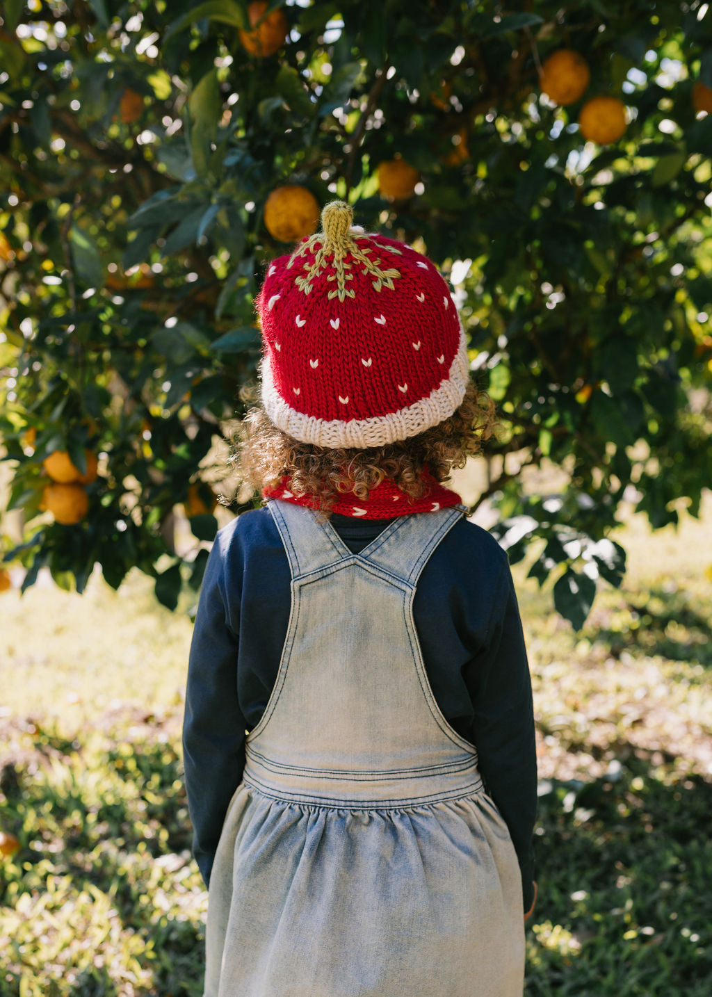 Strawberry Beanie – kids hand-knitted beanie with strawberry, flower, and leaf design in soft wool blend shown on child - back view – Acorn Kids