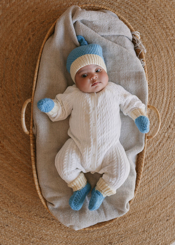Springbud Merino Booties Blue – newborn hand-knitted merino wool booties with moss stitch and rolled cuff shown on a newborn baby – Acorn Kids