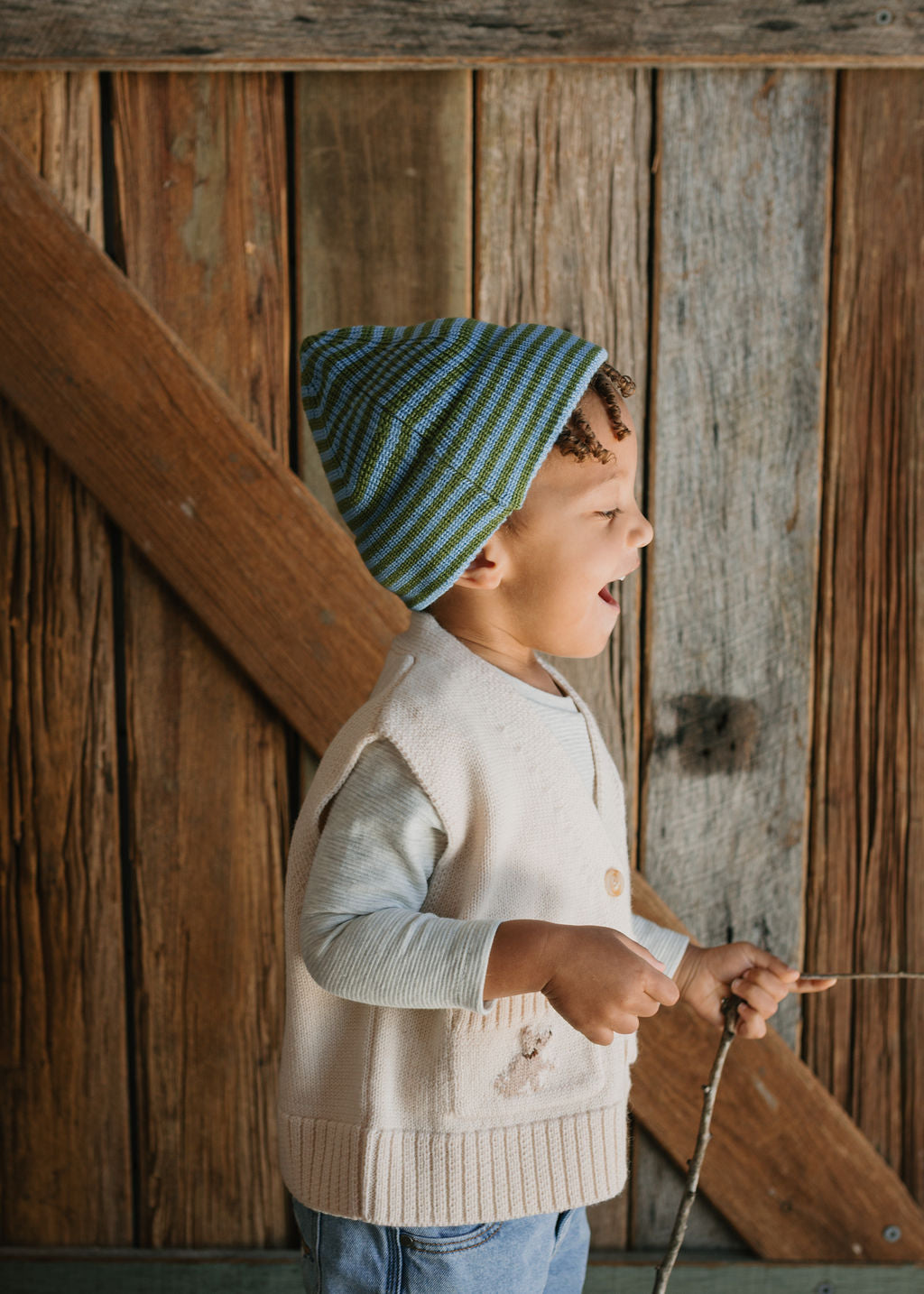 Berlin Merino Beanie Green & Blue Stripe on child side view – kids knitted merino wool striped beanie with pointed top – Acorn Kids