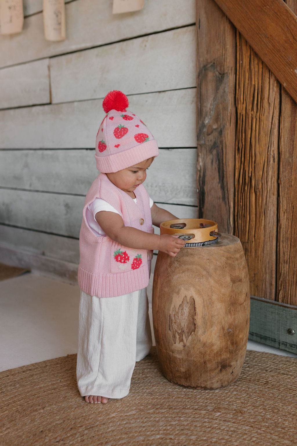 Strawberry Fields Merino Beanie on child side view – kids knitted merino wool beanie with strawberry design and pom pom – Acorn Kids