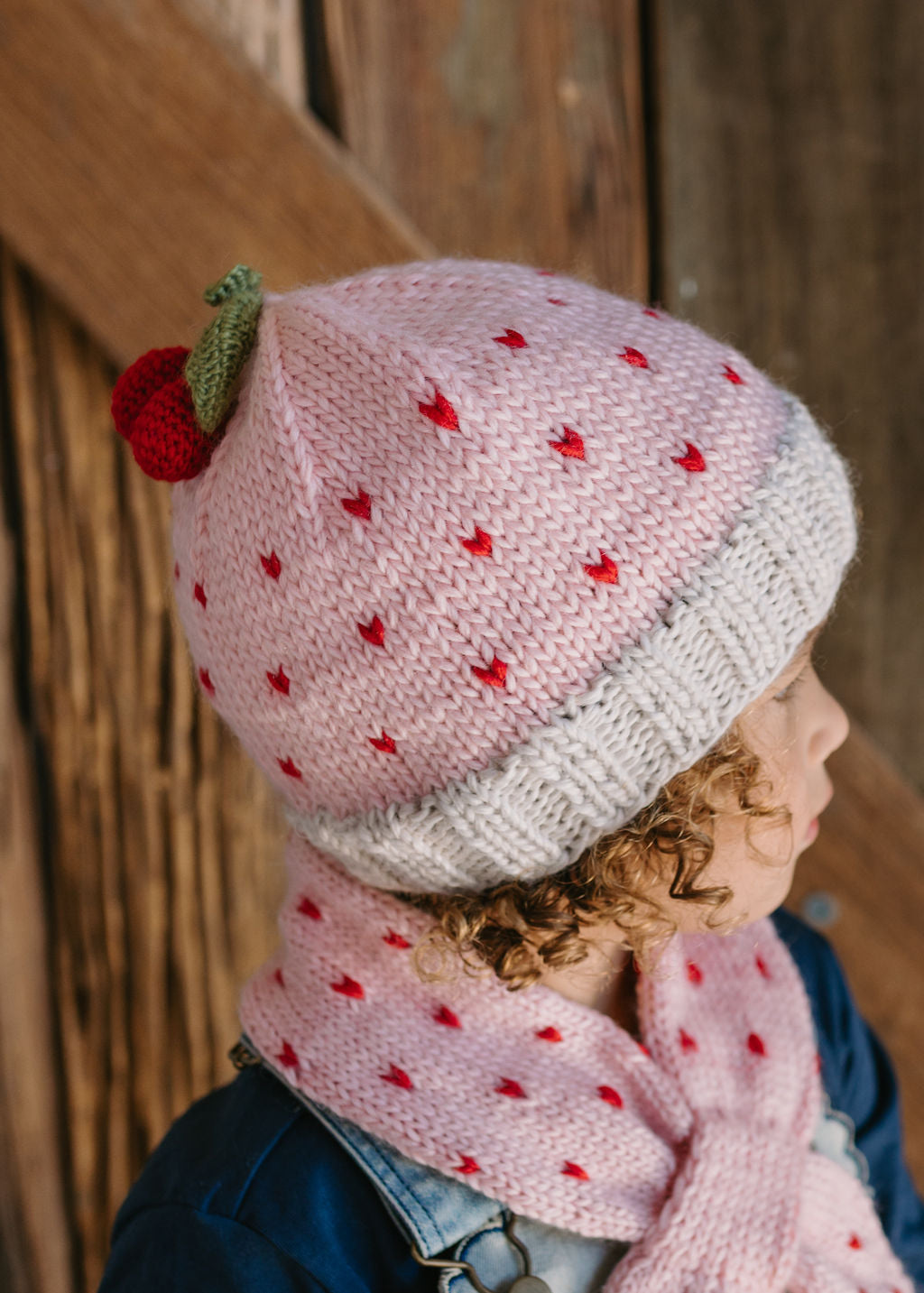 Cherry Beanie – kids hand-knitted pink beanie with crochet cherry and soft wool blend shown on child - side view – Acorn Kids