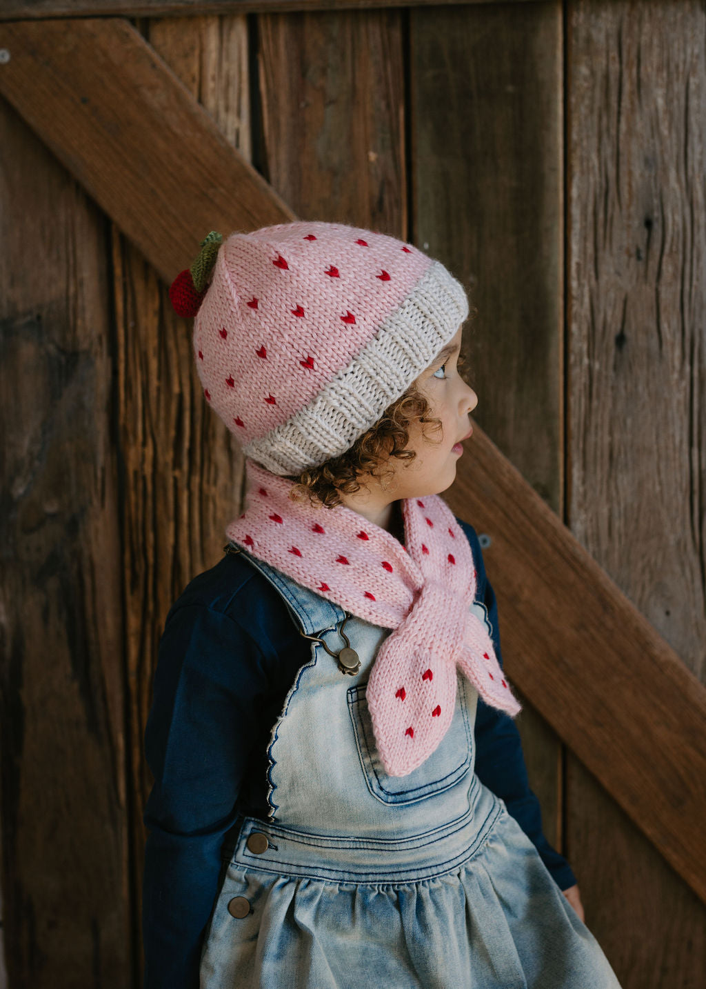 Cherry Beanie – kids hand-knitted pink beanie with crochet cherry and soft wool blend shown on child - side view – Acorn Kids