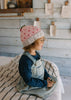 Cherry Beanie – kids hand-knitted pink beanie with crochet cherry and soft wool blend shown on child - side view – Acorn Kids