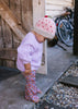 Cherry Beanie – kids hand-knitted pink beanie with crochet cherry and soft wool blend shown on young child - side view – Acorn Kids