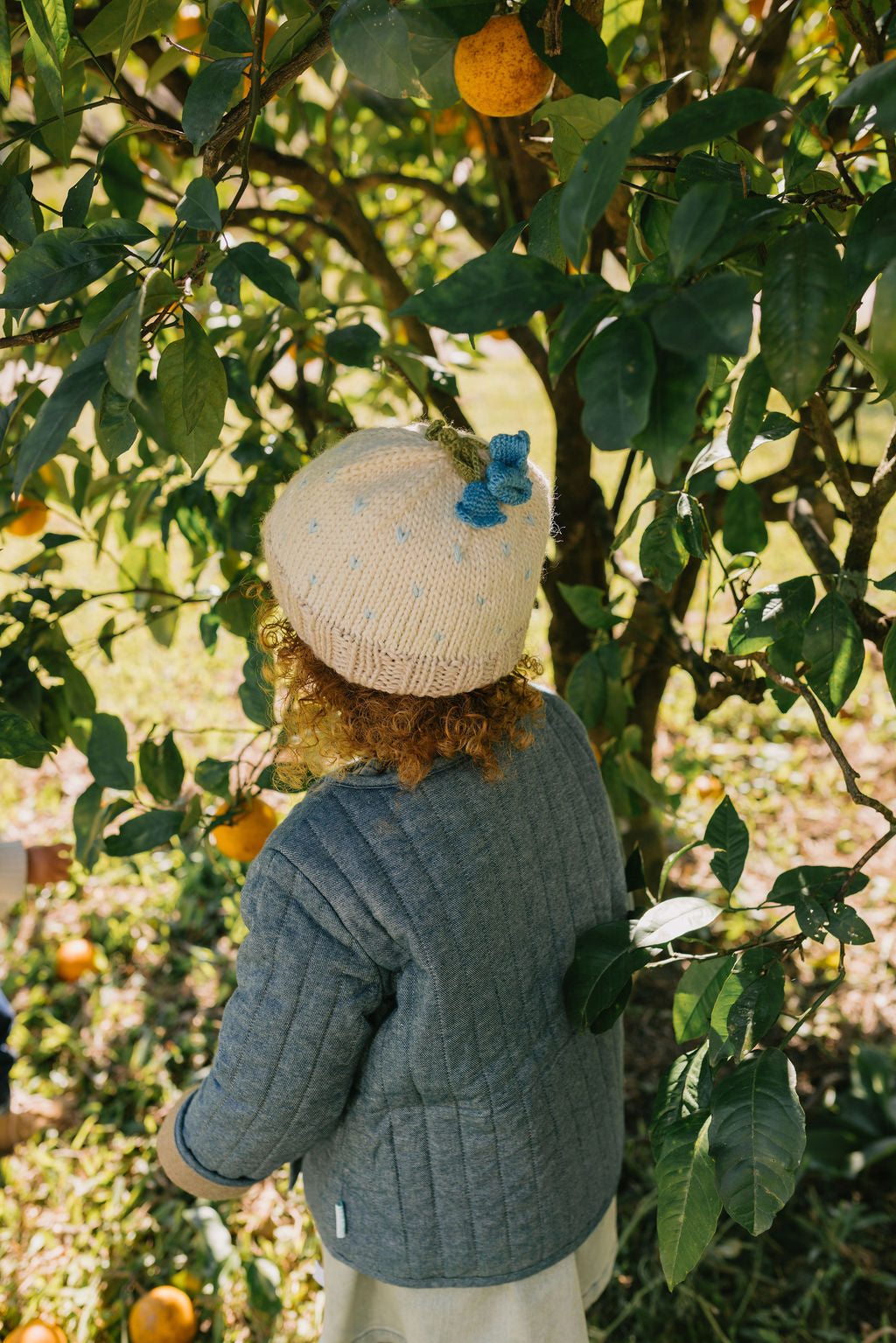 Bluebell Beanie Cream & Blue back view – kids hand-knitted beanie with crochet flower bluebell on top in soft wool blend – Acorn Kids