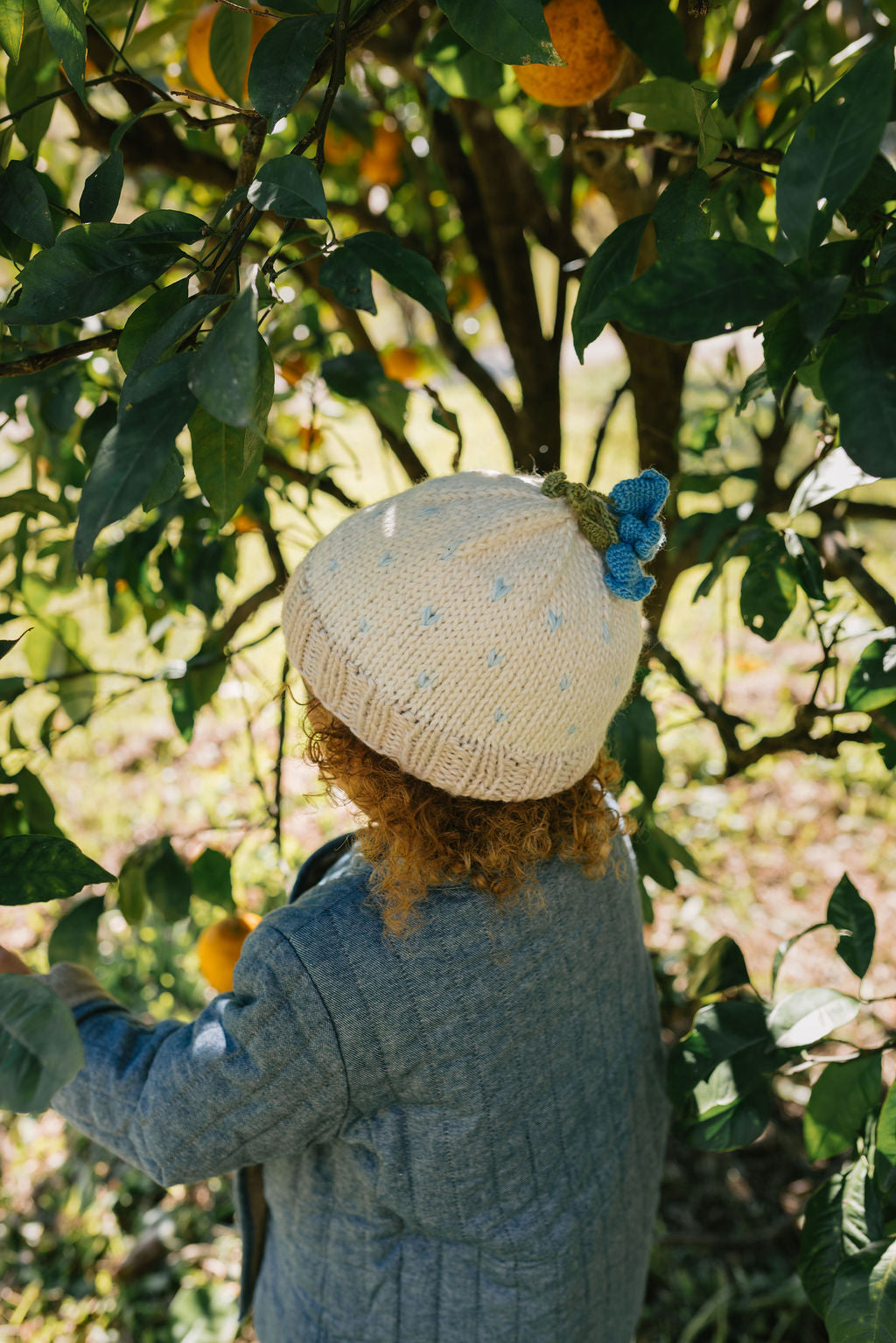 Bluebell Beanie Cream & Blue side view – kids hand-knitted beanie with crochet flower bluebell on top in soft wool blend – Acorn Kids