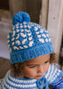Boho Beanie Blue on child close up top view – kids hand-crocheted beanie with two-tone granny square pattern and pom pom – Acorn Kids