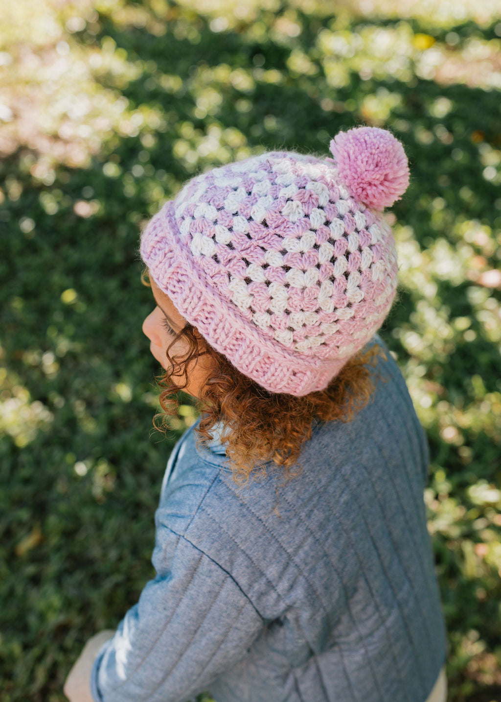 Boho Beanie Pink on child side view – kids hand-crocheted beanie with two-tone granny square pattern and pom pom – Acorn Kids