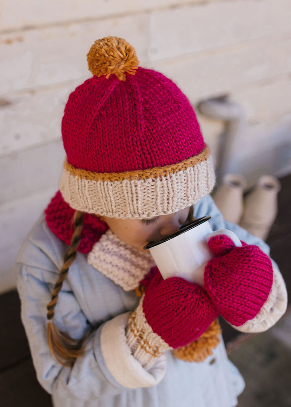 Teddy Beanie Fuchsia & Caramel top view on child– kids hand-knitted beanie with pom pom and contrast trim in soft wool blend – Acorn Kids