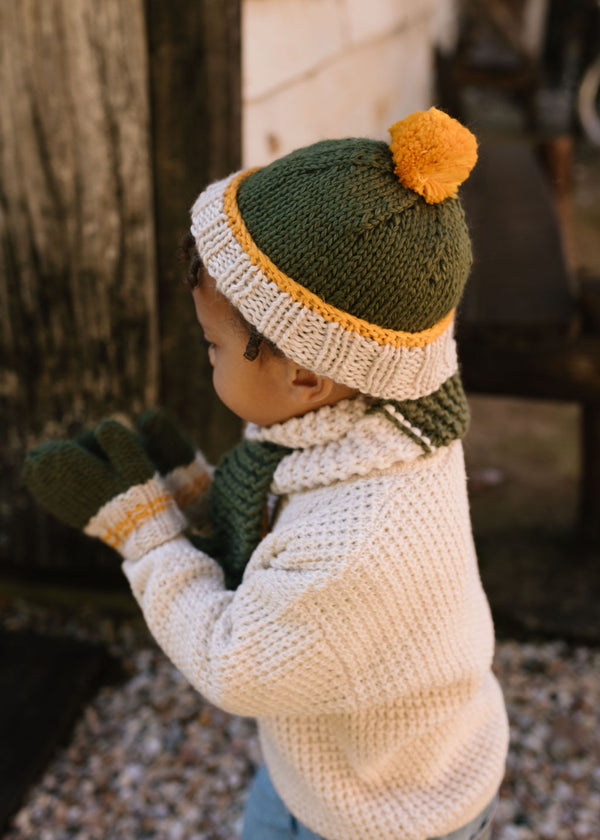 Teddy Beanie Khaki & Gold on child side view – kids hand-knitted beanie with pom pom and contrast trim in soft wool blend – Acorn Kids