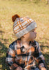 Crossroads Beanie Brown and Caramel on baby side view – kids hand-knitted checked beanie with colourful pom pom in soft wool blend – Acorn Kids