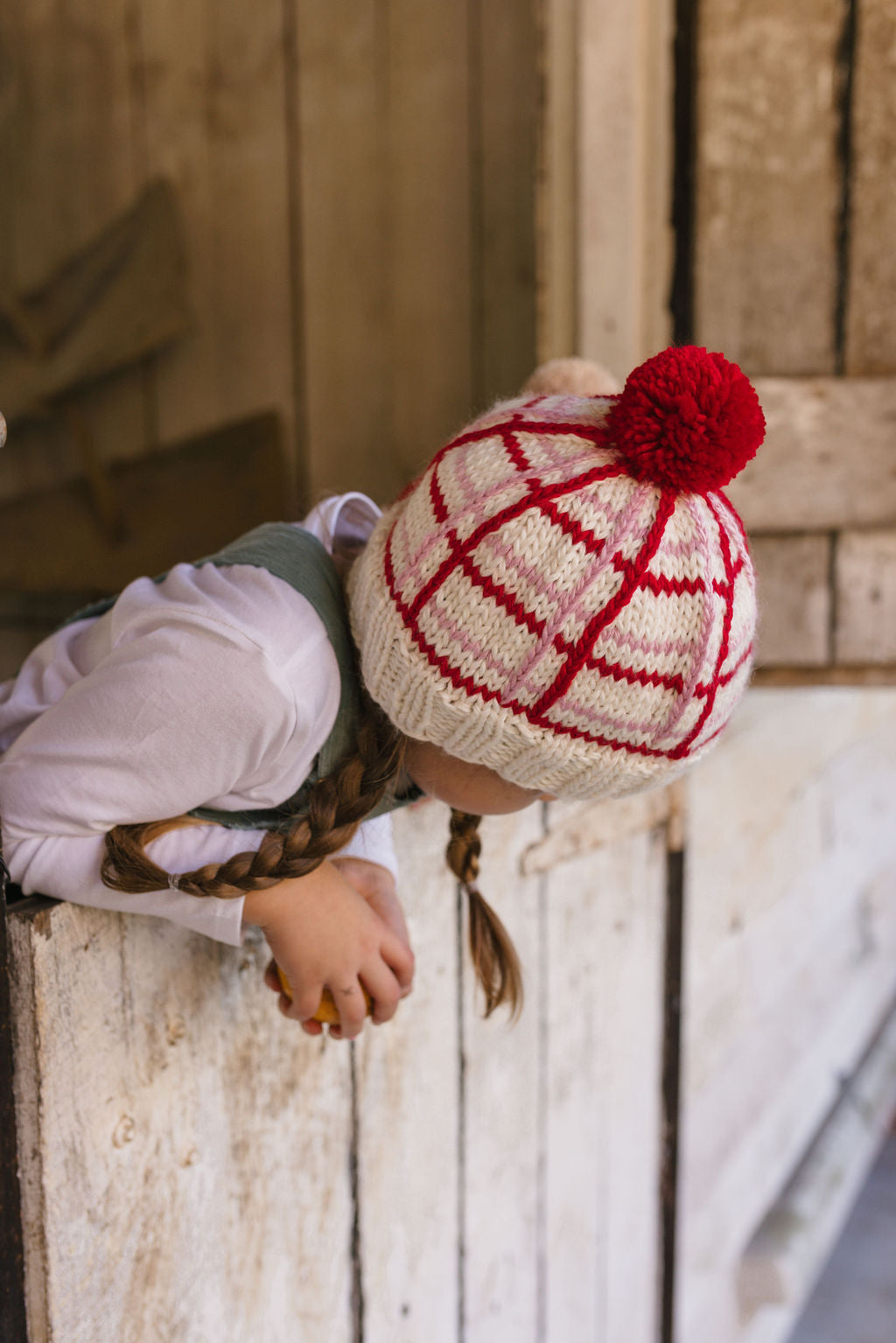 Crossroads Beanie Red and Pink on child back view – kids hand-knitted checked beanie with colourful pom pom in soft wool blend – Acorn Kids