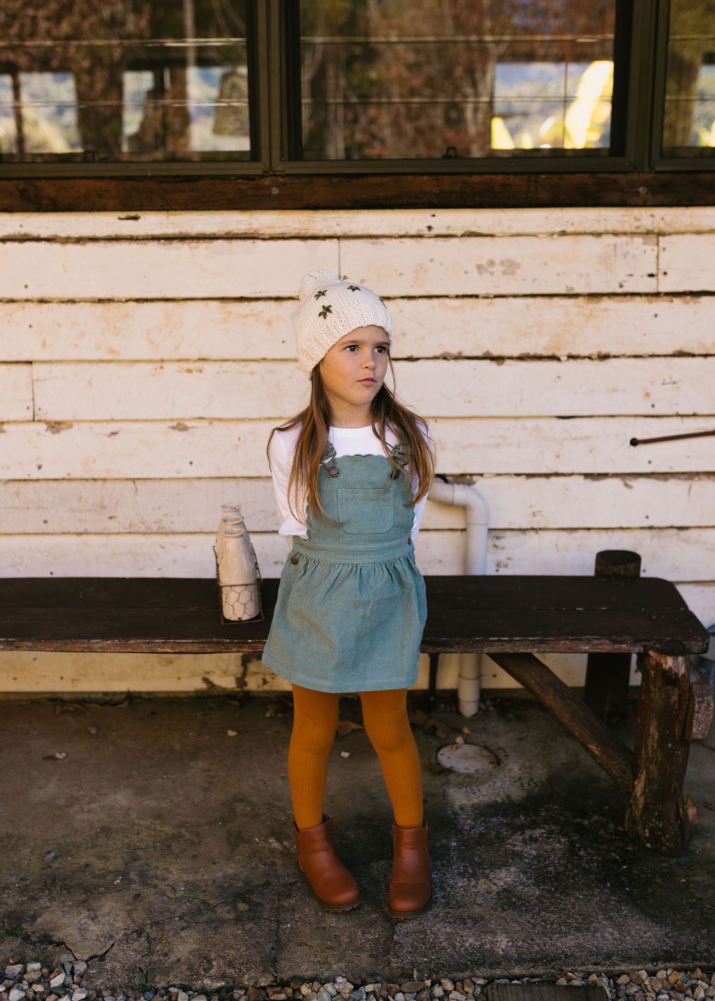 Daisy Beanie – kids hand-knitted beanie with daisy embroidery and pom pom in soft wool blend on child front view – Acorn Kids