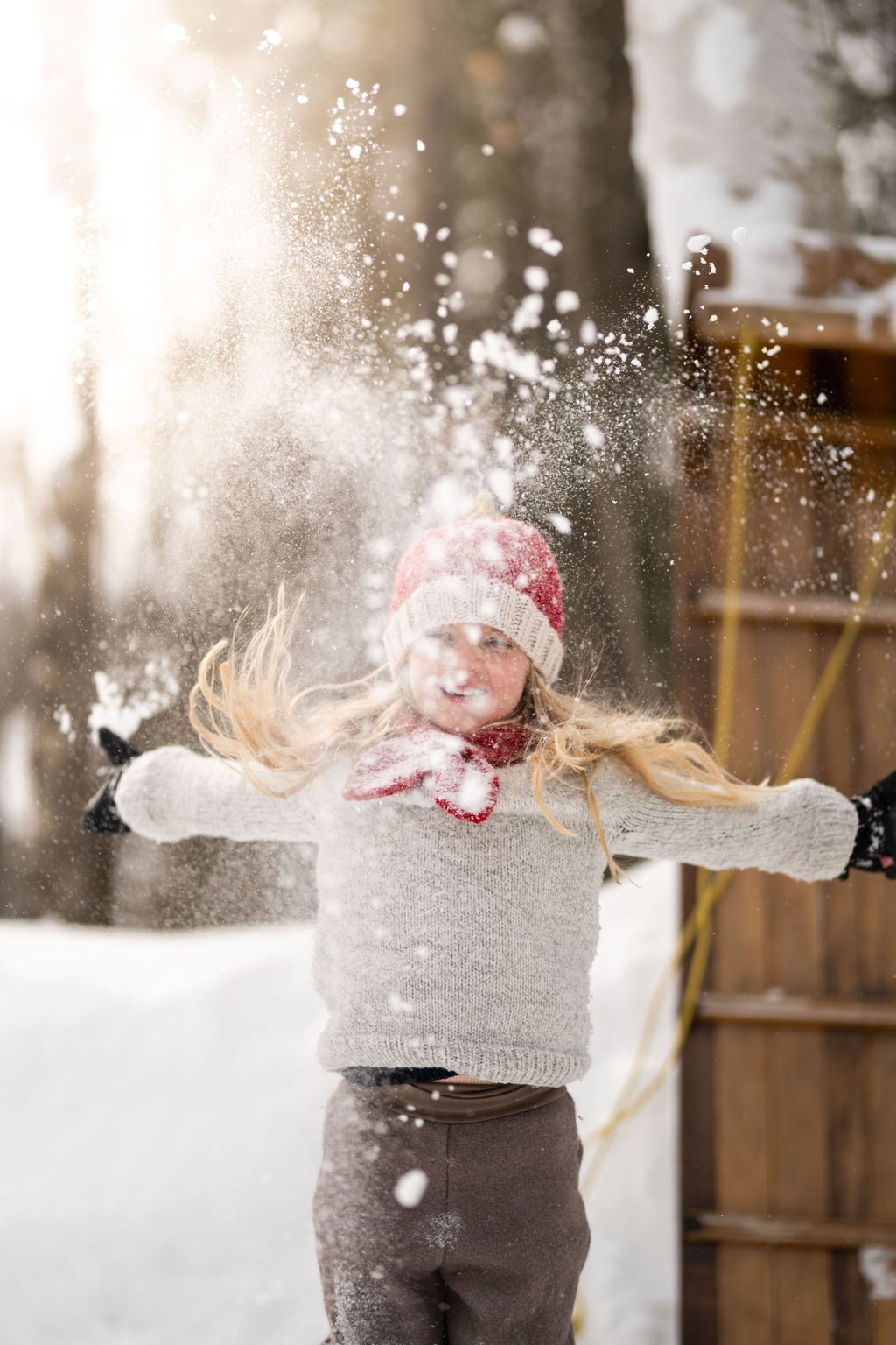 Strawberry Cross Over Scarf – kids hand-knitted red and white scarf with strawberry design in soft wool blend – shown on child - front view - Acorn Kids