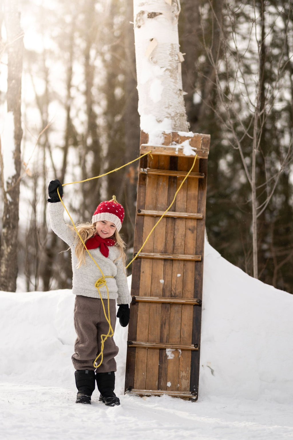 Strawberry Cross Over Scarf – kids hand-knitted red and white scarf with strawberry design in soft wool blend – shown on child - front view - Acorn Kids