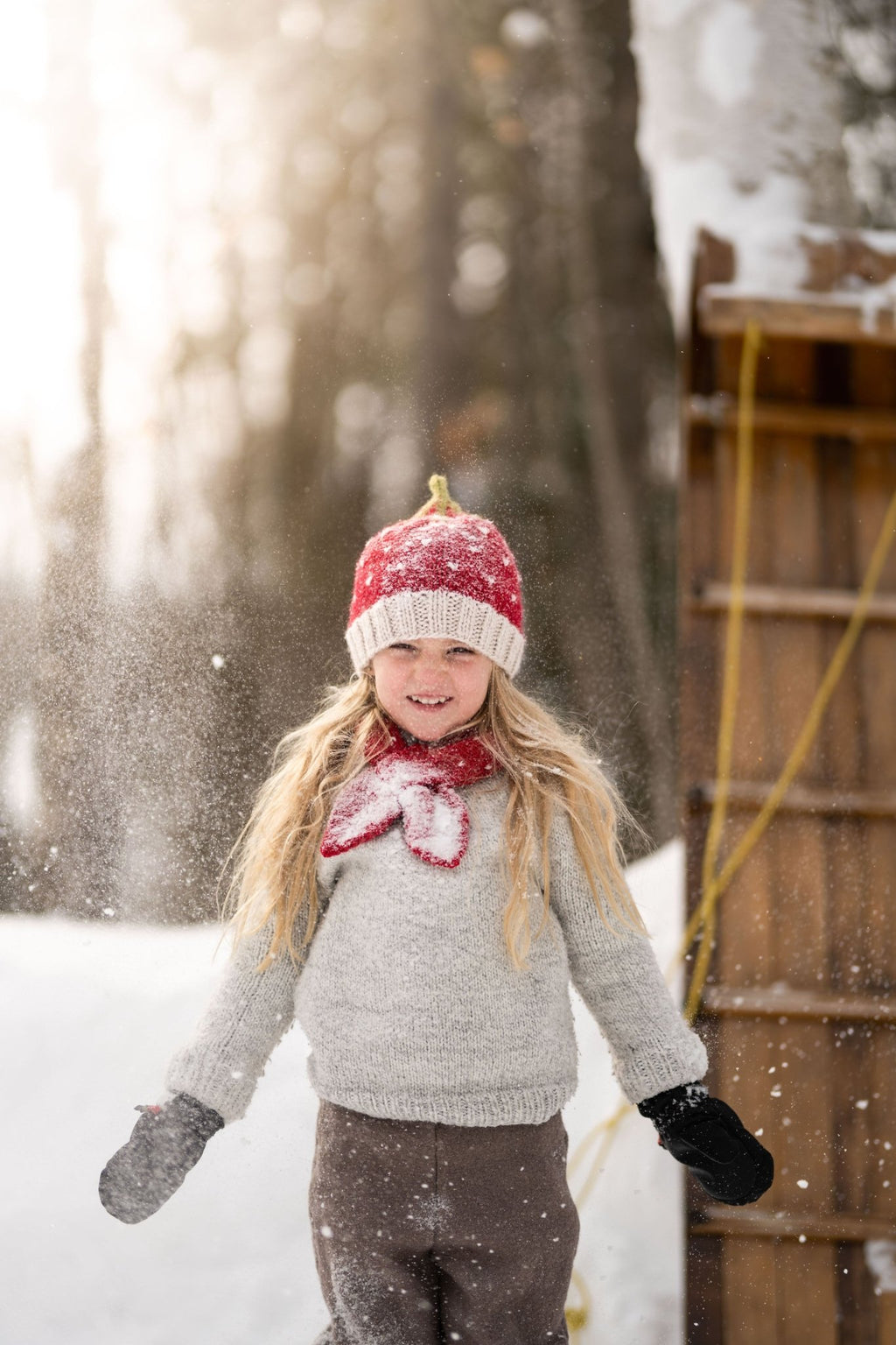 Strawberry Cross Over Scarf – kids hand-knitted red and white scarf with strawberry design in soft wool blend – shown on child - front view - Acorn Kids
